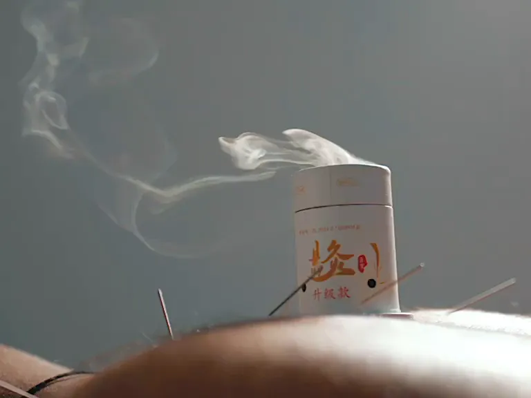 Moxa cup giving steady, controlled warmth over the acupoints